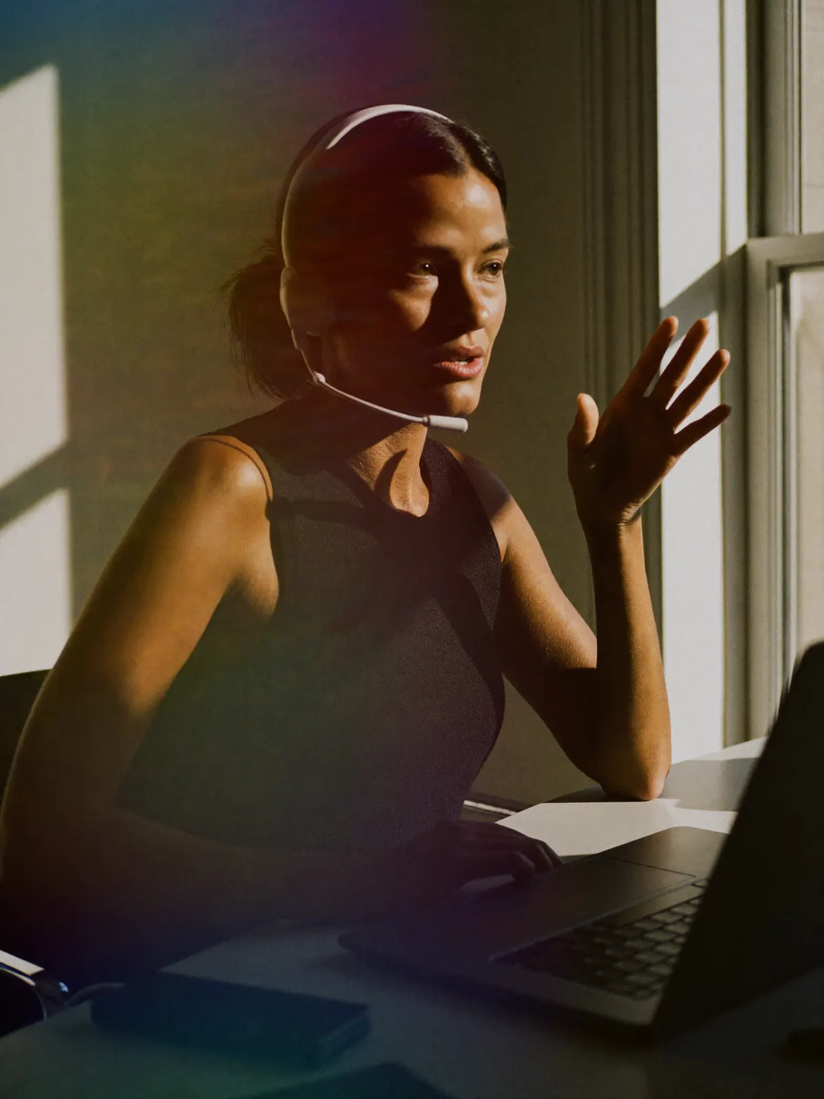 A woman in a headset talking a client through a call at her desk